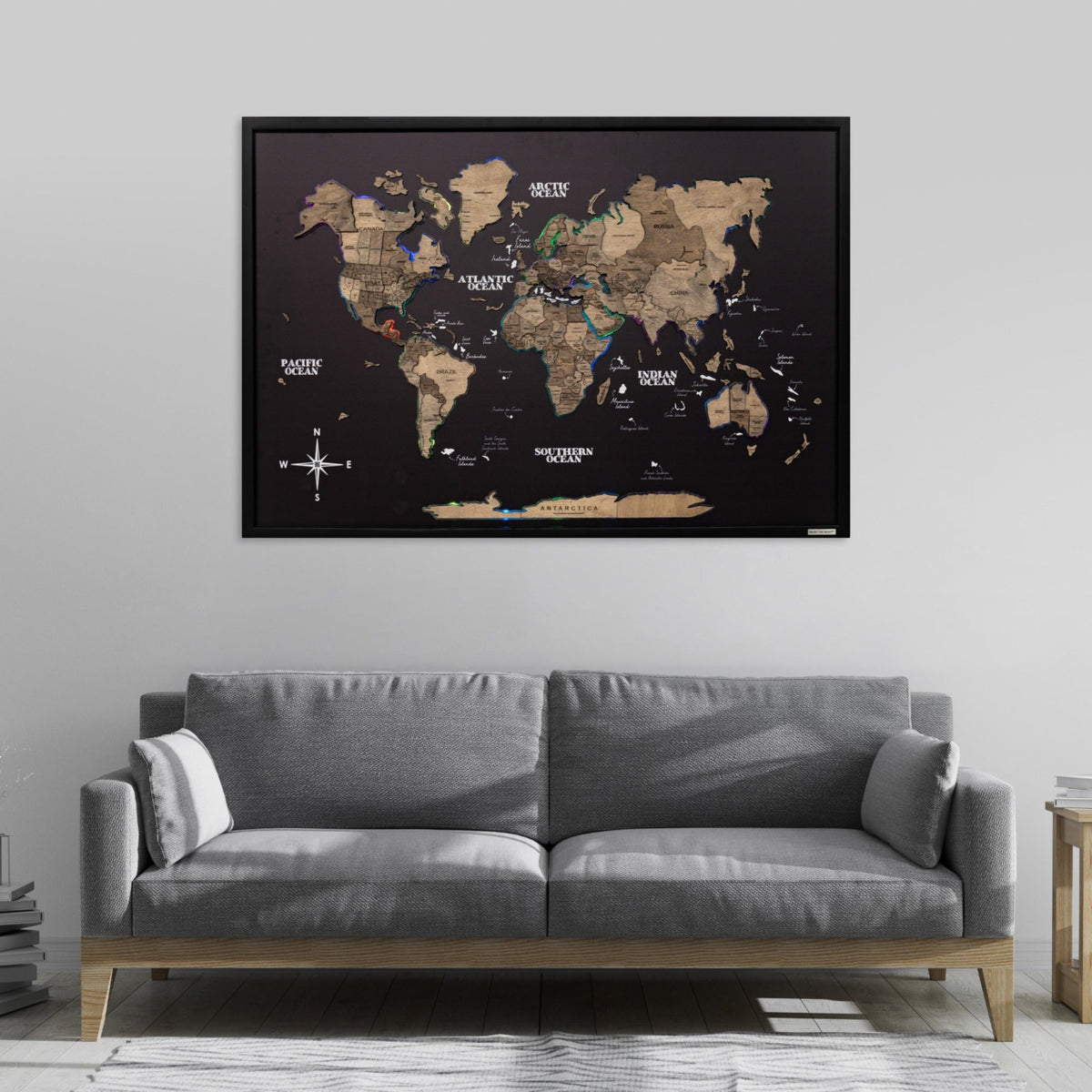 World map poster on a wall above a gray sofa in a living room.