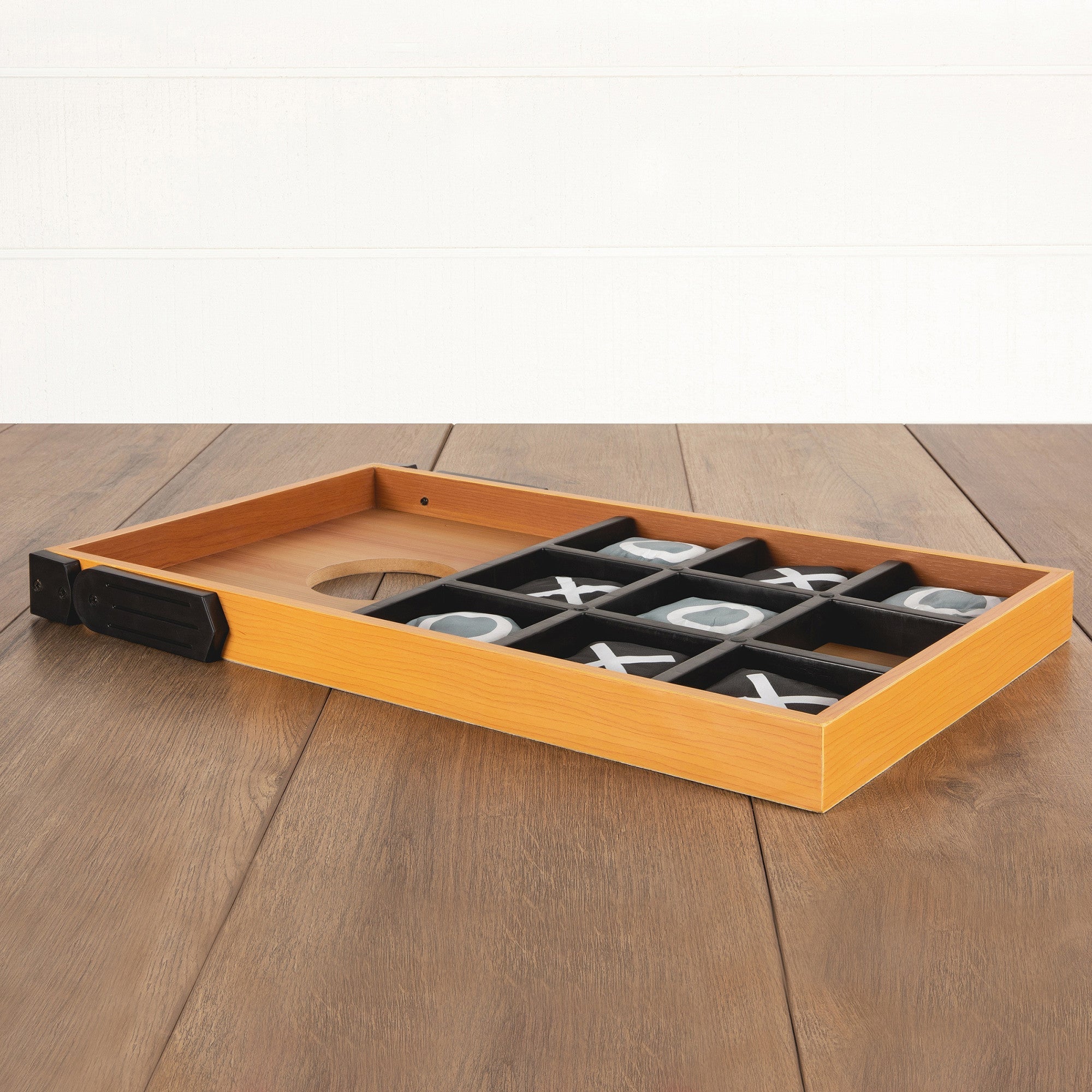 Wooden tic-tac-toe board with pieces on a wooden surface