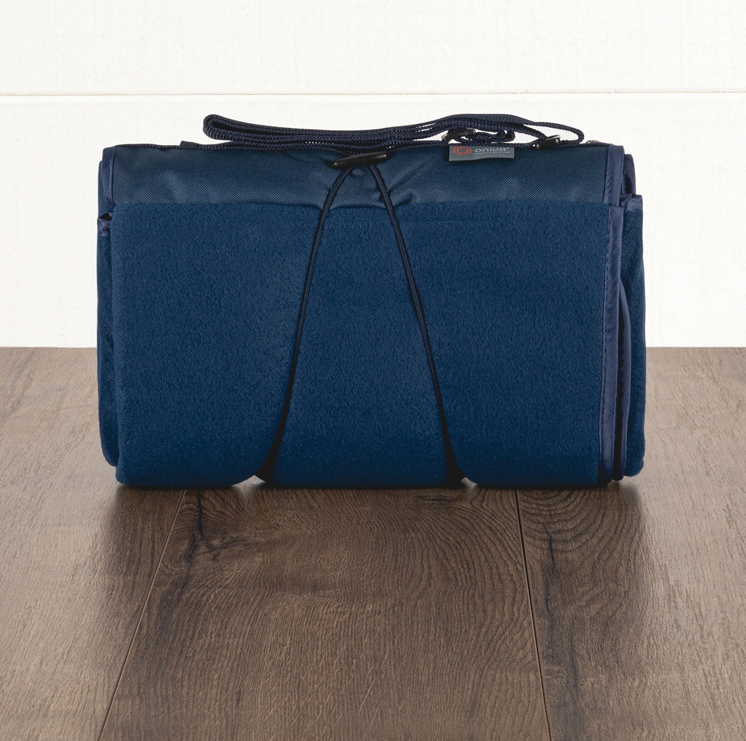 Blue picnic blanket with drawstrings on a wooden surface