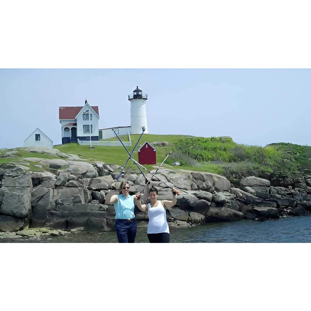 Two people with oars in front of a lighthouse and rocky coastline.