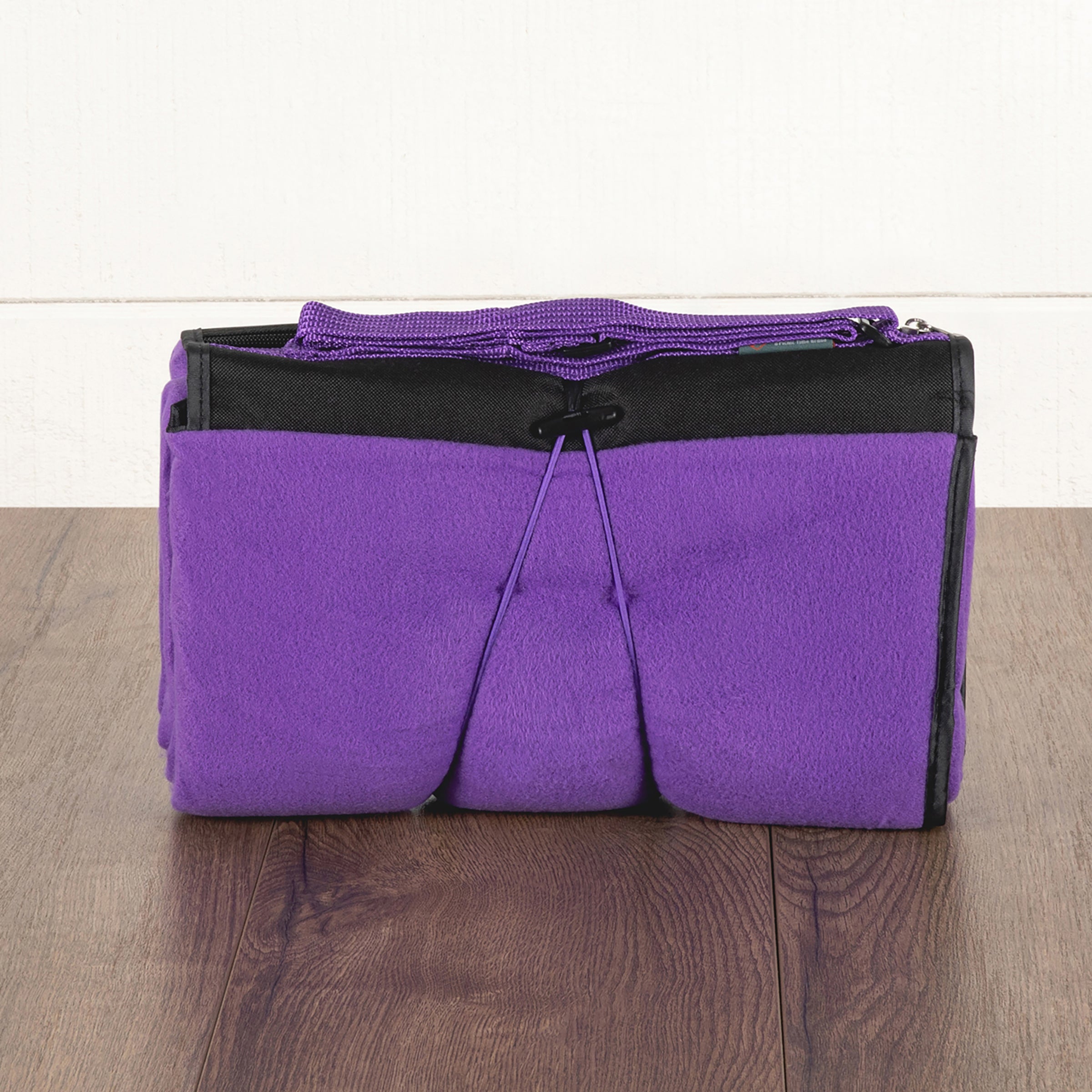 Purple and black bag on a wooden surface with a white background